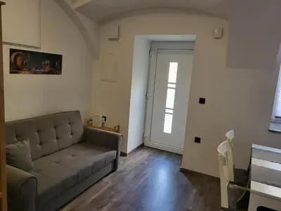 a living room with a couch and a door at MK Studio in Maribor