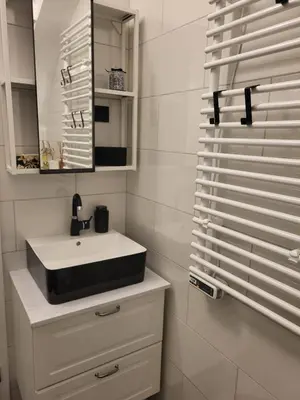 a white bathroom with a sink and a mirror at MK Studio in Maribor