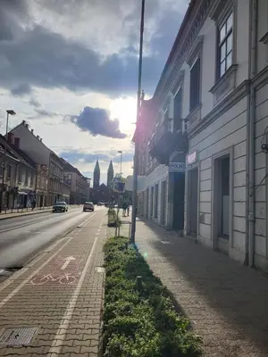 an empty street in a city with the sun shining at MK Studio in Maribor