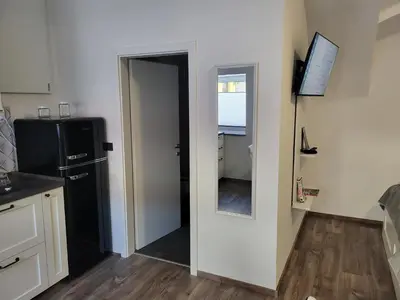 a kitchen with a black refrigerator and a mirror at MK Studio in Maribor