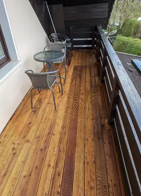 a patio with chairs and tables on a deck at Apartment Zupan in Preddvor