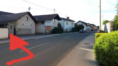 a street with a red arrow on the road at Helena in Trzin
