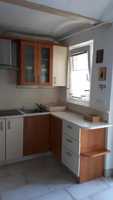 a kitchen with wooden cabinets and a window at Helena in Trzin