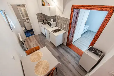 a small kitchen with a table and a sink at Way to the Castle in Ljubljana