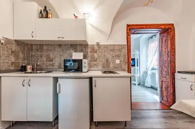 a kitchen with white cabinets and a counter top at Way to the Castle in Ljubljana