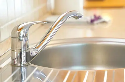 a stainless steel sink with a faucet in a kitchen at Apartments Pr' Pavleto in Bohinj