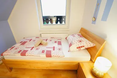 a bed with two pillows and a window in a room at Apartments Pr' Pavleto in Bohinj