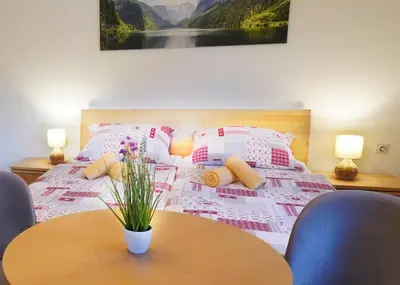 a bedroom with a bed with a table and chairs at Apartments Pr' Pavleto in Bohinj