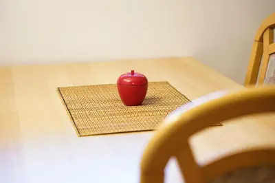 a red apple sitting on a mat on a table at Apartments Pr' Pavleto in Bohinj