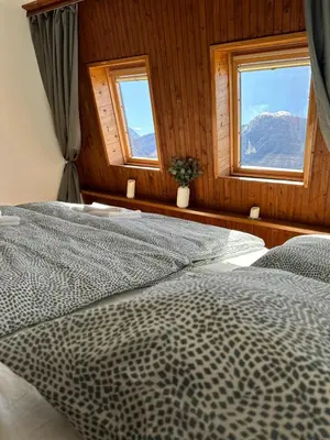 a bedroom with two beds and two windows at App Bovec in Bovec