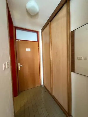 a hallway with a wooden door and a tile floor at App Bovec in Bovec