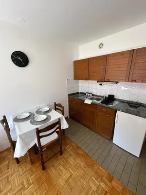 a kitchen with a white table and a white refrigerator at App Bovec in Bovec
