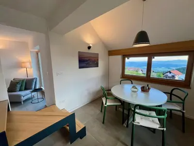 a kitchen and living room with a table and chairs at Elipa Cottage in Cerklje na Gorenjskem