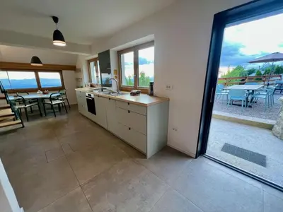 a kitchen with a view of a patio with a table at Elipa Cottage in Cerklje na Gorenjskem