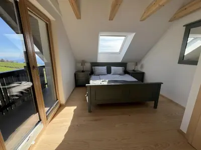 a bedroom with a bed and a large window at Elipa Cottage in Cerklje na Gorenjskem