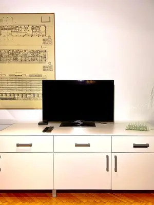 a white entertainment center with a flat screen tv on it at Apartment KOZOLEC - best central location in Ljubljana
