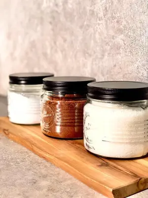 three jam jars on a wooden cutting board at Apartment KOZOLEC - best central location in Ljubljana