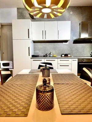 a kitchen with a table and a yellow and white kitchen at Apartment KOZOLEC - best central location in Ljubljana