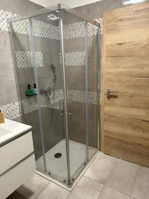 a shower with a glass door in a bathroom at Apartma Anže Samec in Dobravlje