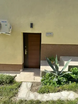 a door to a building with a plant in front of it at Apartma Anže Samec in Dobravlje