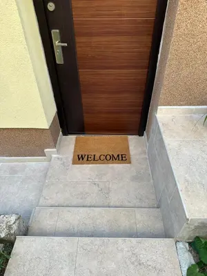 a welcome sign in front of a wooden door at Apartma Anže Samec in Dobravlje