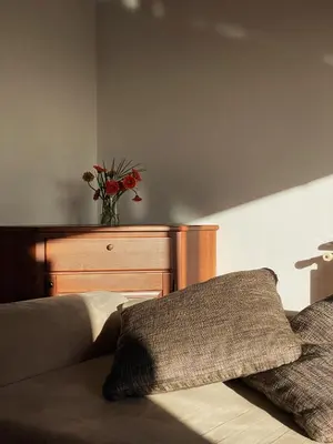 a vase of flowers sitting on top of a bed at Apartma Domačija Bole in Sežana