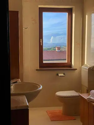 a bathroom with a sink and a toilet and a window at Apartma Domačija Bole in Sežana