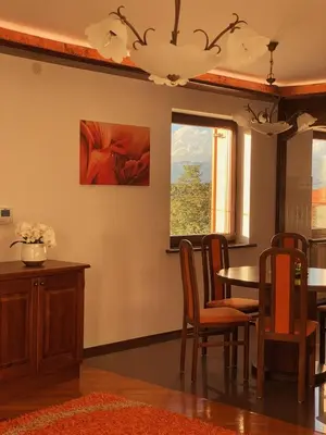 a dining room with a table and chairs and a window at Apartma Domačija Bole in Sežana