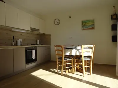 a kitchen with a table and chairs and a clock on the wall at Apartment Josephine in Tolmin