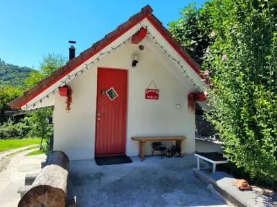 a small house with a red door and a picnic table at Babičina hišica in Mišji Dol