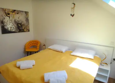 a bedroom with a large yellow bed with two pillows at Apartment 14 Luna in Bovec