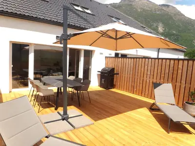a patio with a table and chairs and an umbrella at Apartment 14 Luna in Bovec