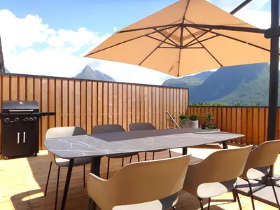 a table and chairs with an umbrella on a deck at Apartment 14 Luna in Bovec