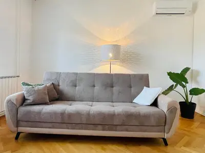a couch in a living room with a lamp at Apartma Srečko, Sežana in Sežana