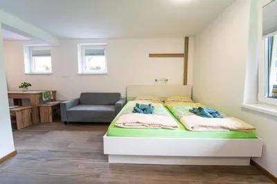a bedroom with a bed and a chair at apartment Sun Di Bohinj in Bohinj