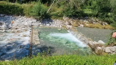 a pool of water next to a river at apartment Sun Di Bohinj in Bohinj
