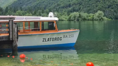 a boat sitting in the water next to a dock at apartment Sun Di Bohinj in Bohinj