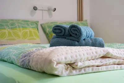 a pile of towels sitting on top of a bed at apartment Sun Di Bohinj in Bohinj