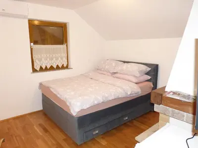 a bedroom with a bed with pink pillows and a mirror at Vineyard cottage Mavrica in Dragatuš