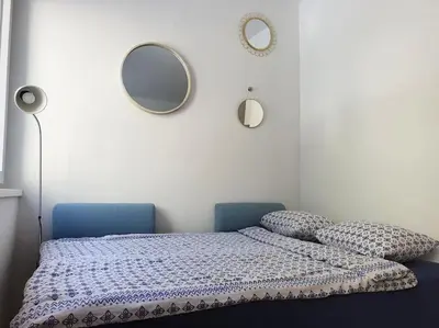 a bedroom with a bed with two mirrors on the wall at Happy Vibes apartment, charming & with free parking in Ljubljana