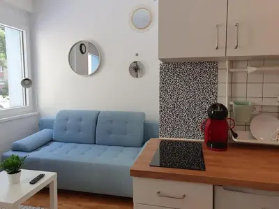 a living room with a blue couch in a kitchen at Happy Vibes apartment, charming & with free parking in Ljubljana