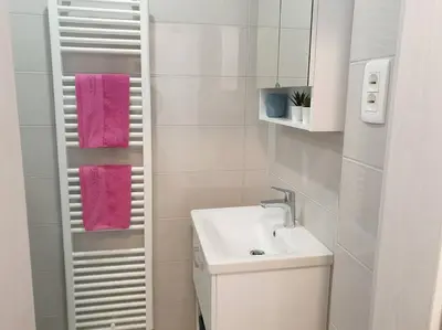 a white bathroom with a sink and a mirror at Happy Vibes apartment, charming & with free parking in Ljubljana