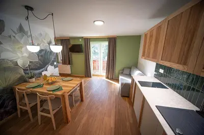 a kitchen with a wooden table and a kitchen counter at Turizem na kmetiji Rdečnik in Slovenj Gradec