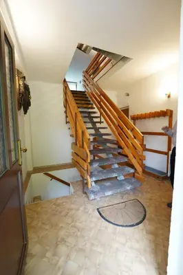 a staircase in a house with a person walking up it at APARTMAJI-SOBE-PRI UKCU Bohinj in Bohinj