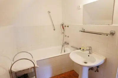 a white bathroom with a sink and a bath tub at APARTMAJI-SOBE-PRI UKCU Bohinj in Bohinj