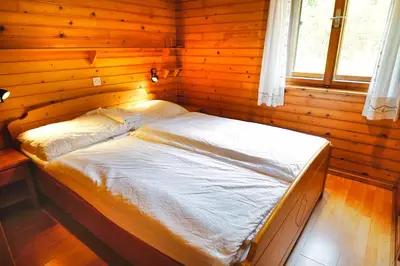 a bedroom with a bed in a wooden room at APARTMAJI-SOBE-PRI UKCU Bohinj in Bohinj