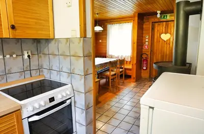 a kitchen with a stove and a sink and a table at APARTMAJI-SOBE-PRI UKCU Bohinj in Bohinj