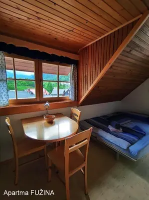 a room with a table and a bed in a cabin at Apartments Cesar in Bohinj