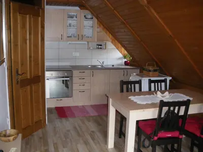 a kitchen with a table and a stove and a sink at Apartments Cesar in Bohinj