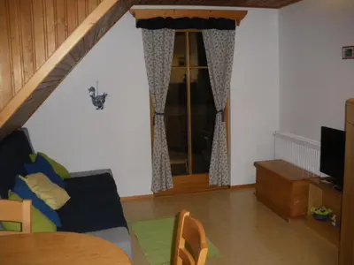 a living room with a couch and a window at Apartments Cesar in Bohinj